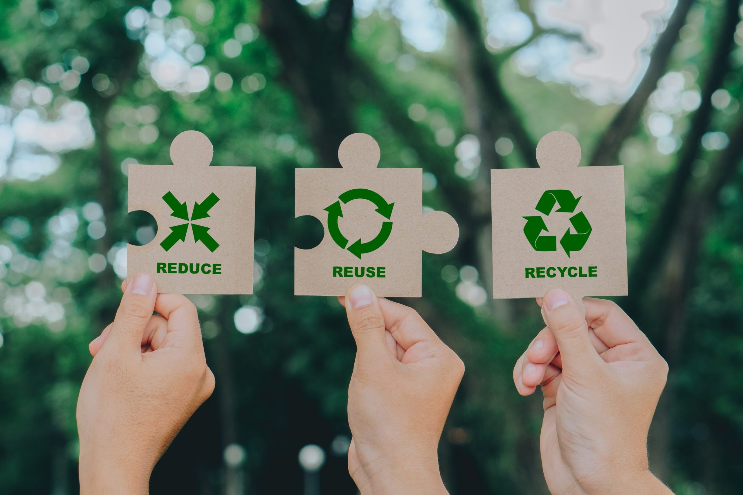 Hand holding Jigsaw with reduce, reuse, recycle symbol on green background. Ecological and save the earth concept.Ecological waste management and a sustainable.Teamwork,renewable,responsibility concept