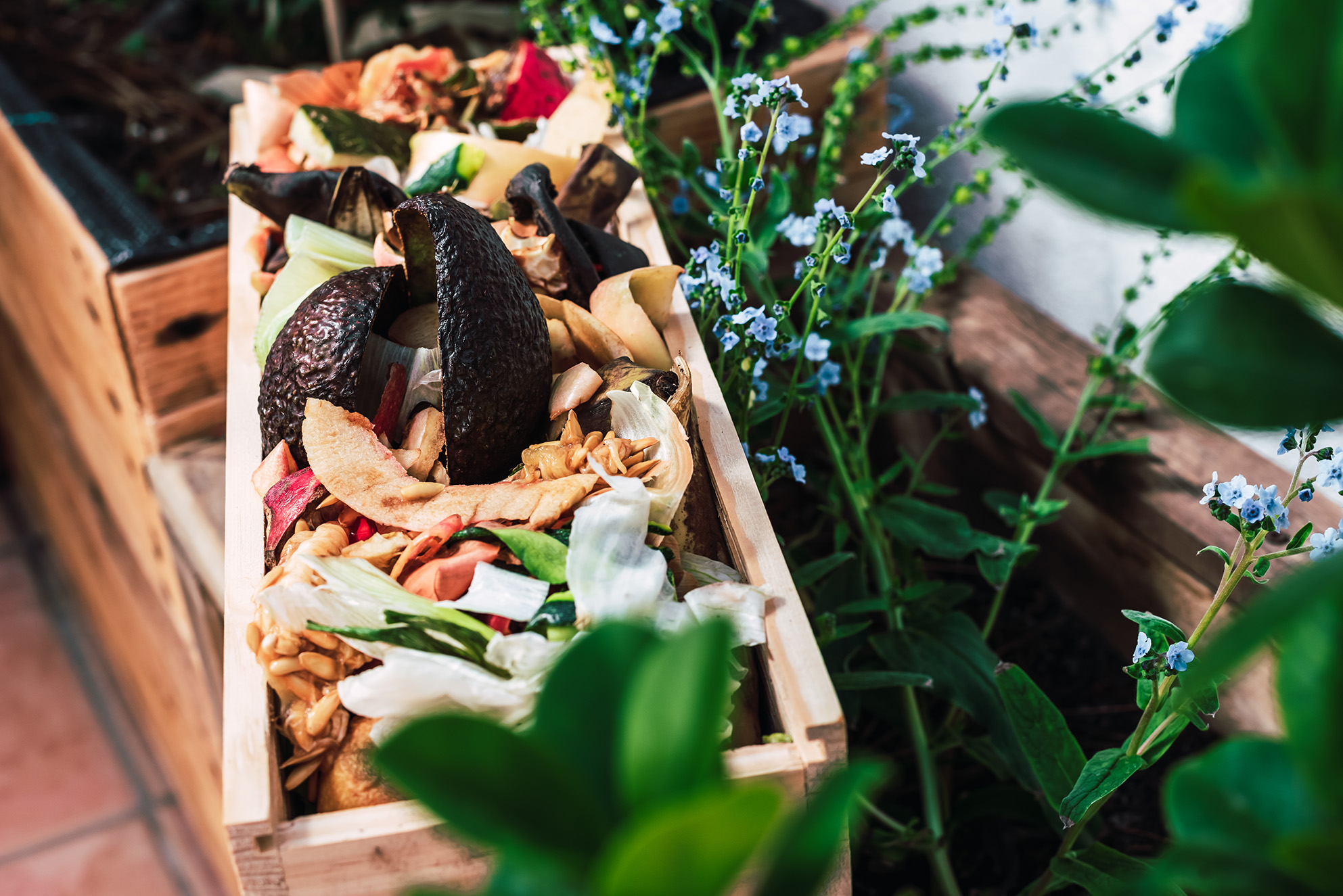 Peelings and organic waste in a wooden crate to create homemade compost